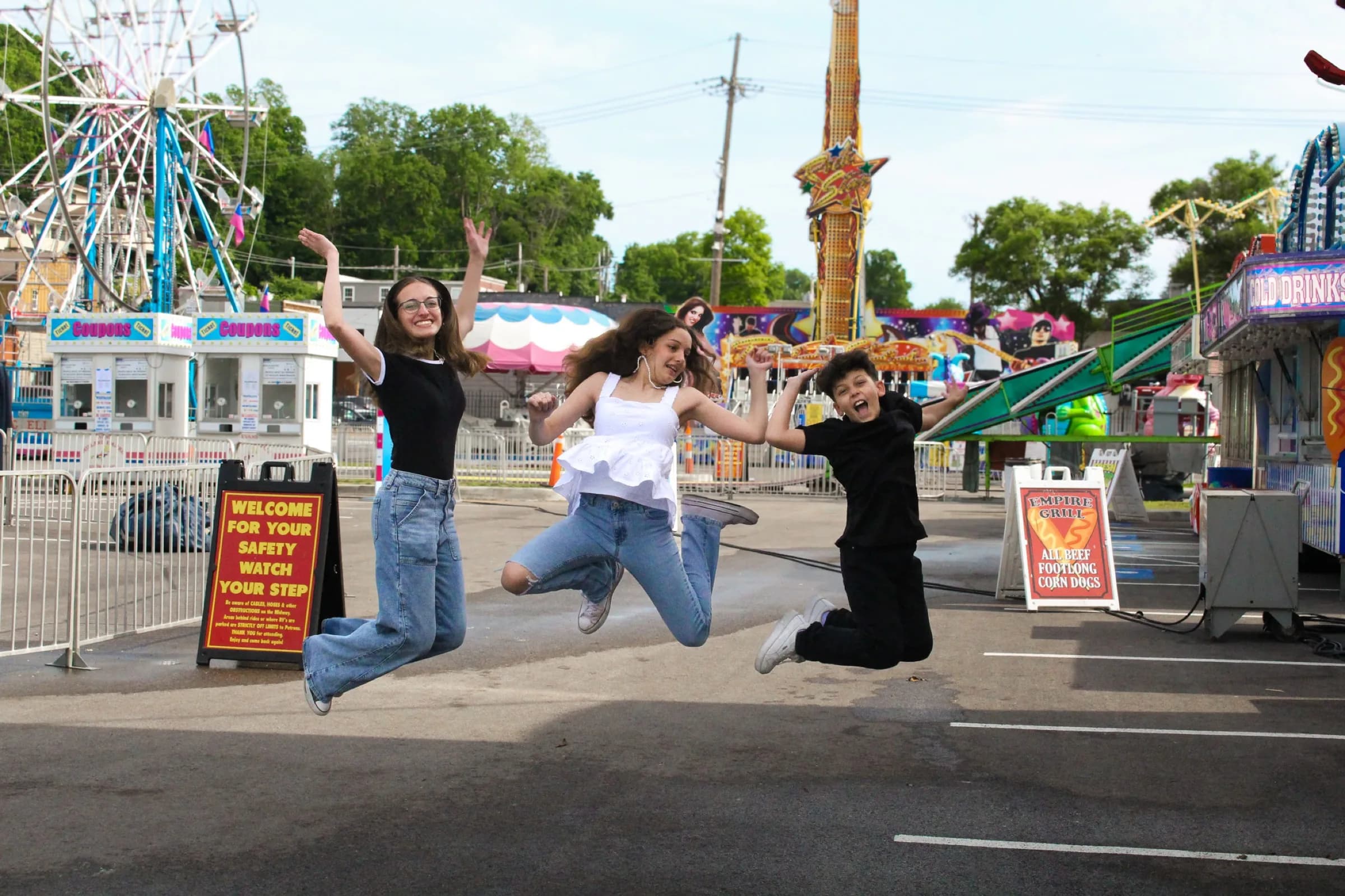 Three people jumping at fair