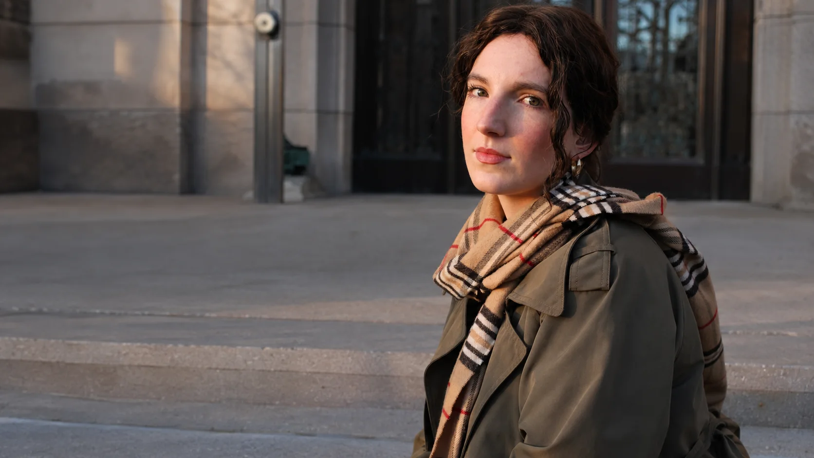 Anna seated on city steps in warm evening light