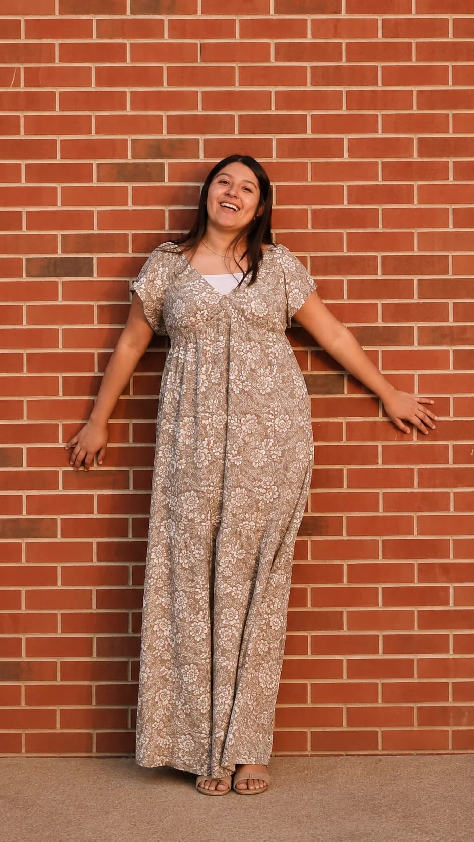 Smiling woman posed against a brick wall
